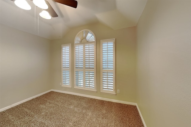 carpeted spare room featuring vaulted ceiling and ceiling fan