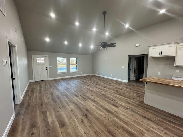 unfurnished living room featuring ceiling fan, dark hardwood / wood-style floors, and high vaulted ceiling