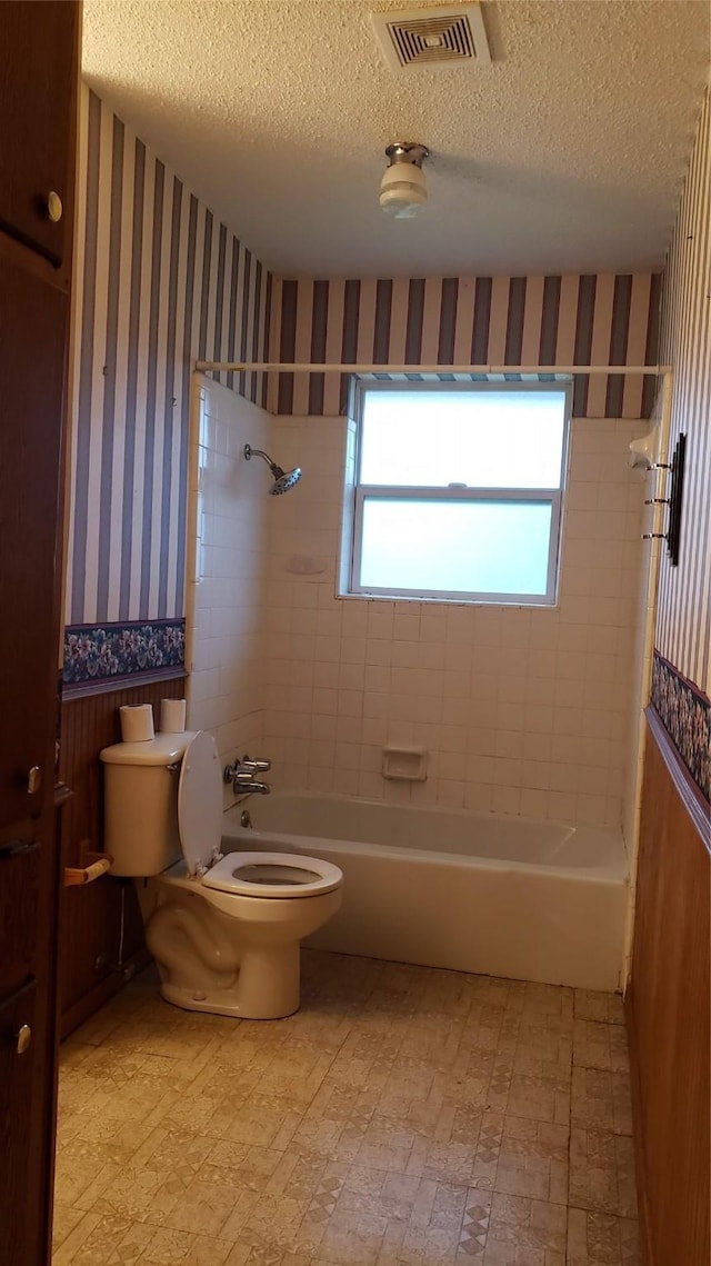 1802 SE 26th Ave, Mineral Wells, TX 76067 - full bathroom featuring wallpapered walls, bathtub / shower combination, toilet, and a textured ceiling