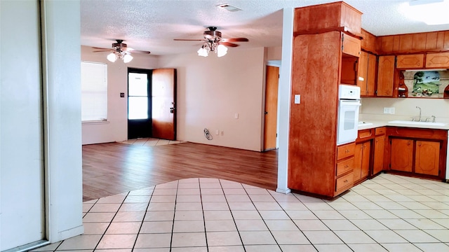 1802 SE 26th Ave, Mineral Wells, TX 76067 - kitchen featuring oven, a sink, light countertops, ceiling fan, and a textured ceiling