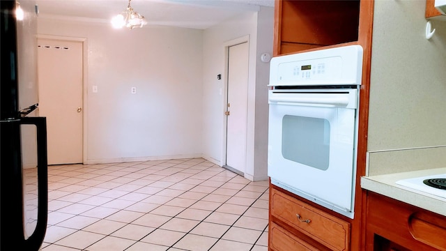 1802 SE 26th Ave, Mineral Wells, TX 76067 - kitchen featuring oven, light countertops, light tile patterned flooring, and brown cabinets
