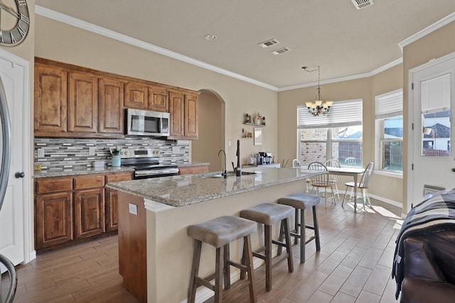 kitchen featuring appliances with stainless steel finishes, sink, and a center island with sink