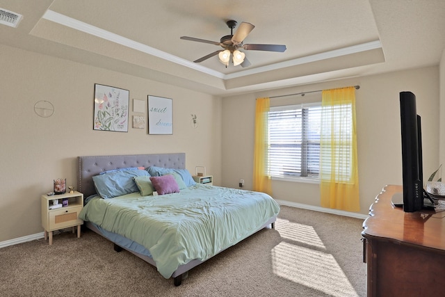 carpeted bedroom featuring ornamental molding, a raised ceiling, and ceiling fan