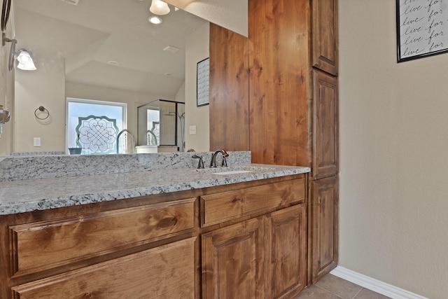 bathroom with tile patterned floors, vaulted ceiling, and vanity