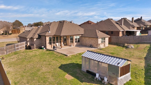 back of house featuring a patio, an outdoor structure, and a lawn