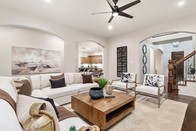 living room with ceiling fan with notable chandelier and light hardwood / wood-style floors