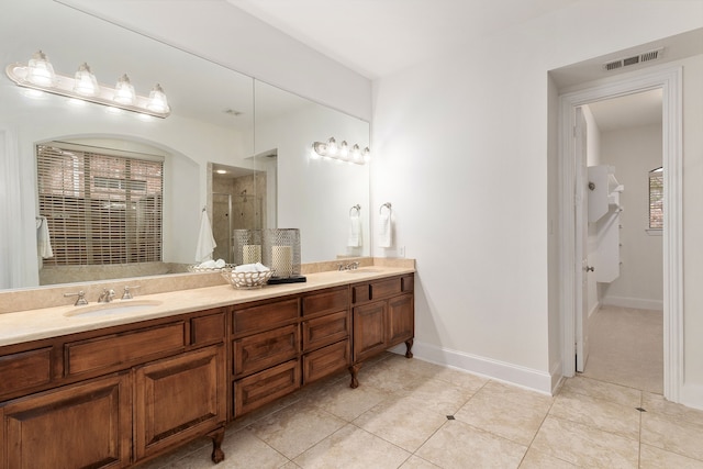 bathroom with a shower with door, vanity, and tile patterned flooring