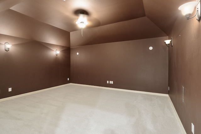 carpeted empty room with lofted ceiling