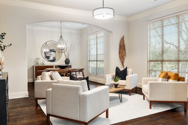 living room with dark hardwood / wood-style flooring, a notable chandelier, and ornamental molding