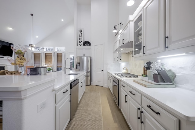 kitchen featuring stainless steel appliances, white cabinetry, and a kitchen island with sink