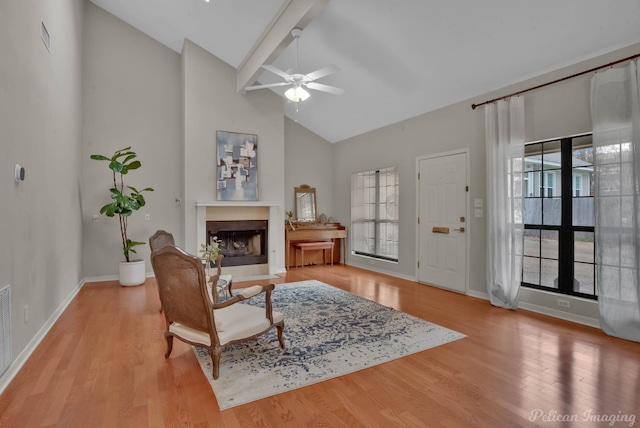 interior space with beamed ceiling, high vaulted ceiling, ceiling fan, and light wood-type flooring