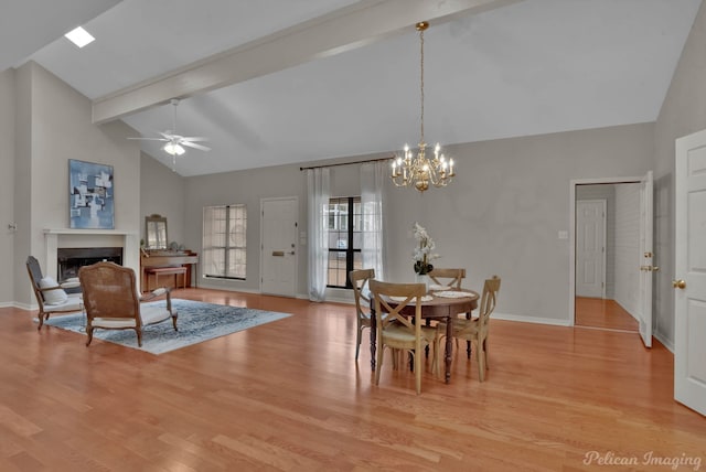 dining room featuring high vaulted ceiling, beam ceiling, ceiling fan with notable chandelier, and light hardwood / wood-style flooring