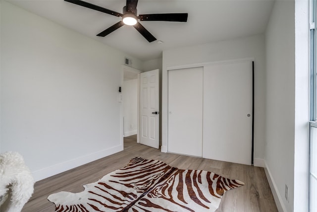 bedroom featuring hardwood / wood-style floors, ceiling fan, and a closet