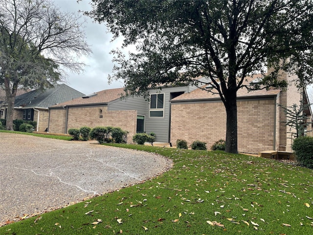 exterior space featuring a yard and brick siding