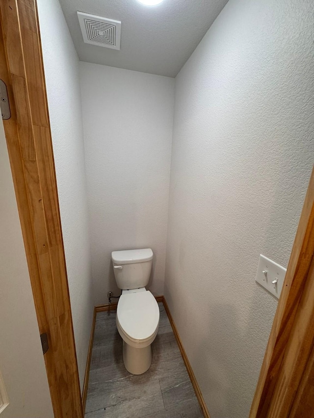 bathroom featuring wood-type flooring and toilet