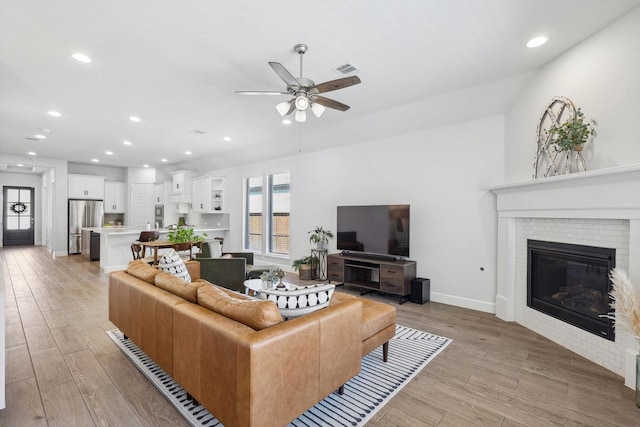 living area with light wood-style floors, visible vents, and a wealth of natural light