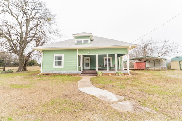 bungalow with a front lawn, a carport, and a porch