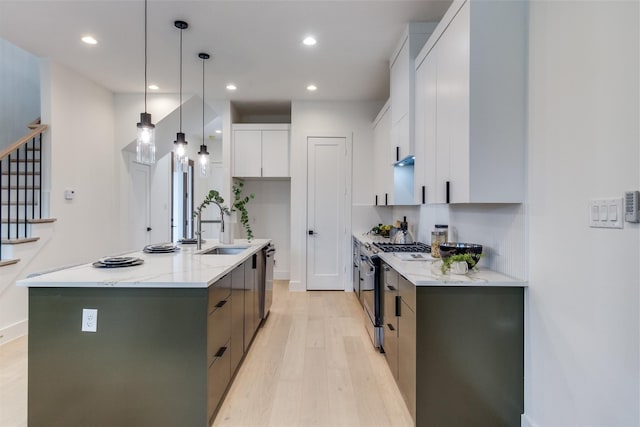 417 Wayne St, Dallas, TX 75223 - kitchen with recessed lighting, light wood finished floors, an island with sink, a sink, and gas range