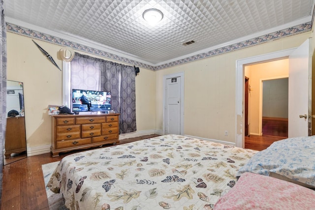 bedroom featuring ornamental molding and dark hardwood / wood-style flooring