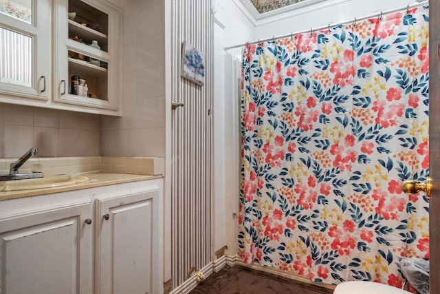 bathroom featuring a shower with curtain, vanity, toilet, and backsplash