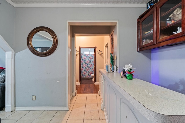 interior space featuring crown molding and light tile patterned flooring