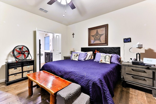 bedroom featuring ceiling fan, ensuite bath, and hardwood / wood-style floors