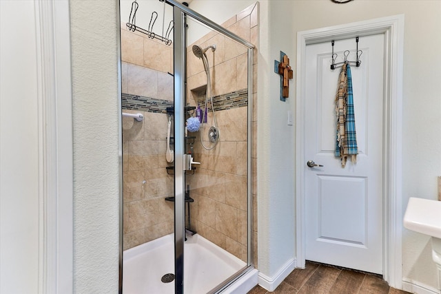 bathroom with an enclosed shower and hardwood / wood-style floors