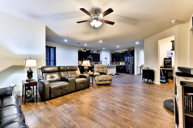 living room with ceiling fan, wood-type flooring, and sink