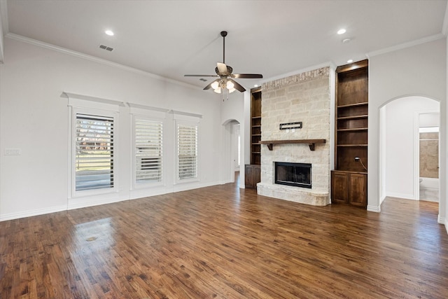 unfurnished living room with dark wood-type flooring, a fireplace, ornamental molding, and ceiling fan