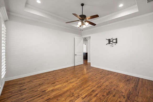 unfurnished bedroom with dark wood-type flooring, ceiling fan, ornamental molding, and a tray ceiling