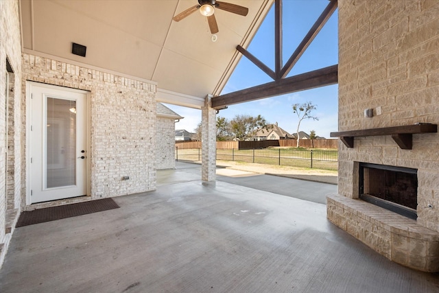 view of patio / terrace featuring ceiling fan and an outdoor stone fireplace