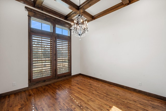 empty room featuring hardwood / wood-style flooring, coffered ceiling, a chandelier, and beamed ceiling