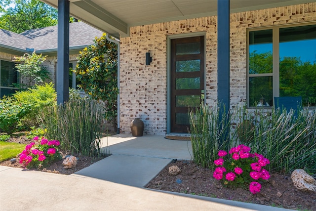 477 Lakepoint Loop, Pottsboro, TX 75076 - doorway to property with brick siding, a shingled roof, and covered porch