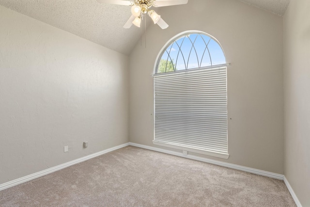 carpeted spare room featuring a ceiling fan, a textured ceiling, baseboards, and lofted ceiling