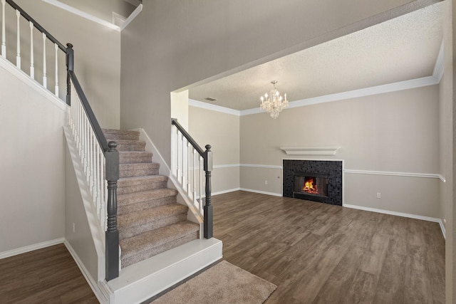 staircase with crown molding, baseboards, and wood finished floors