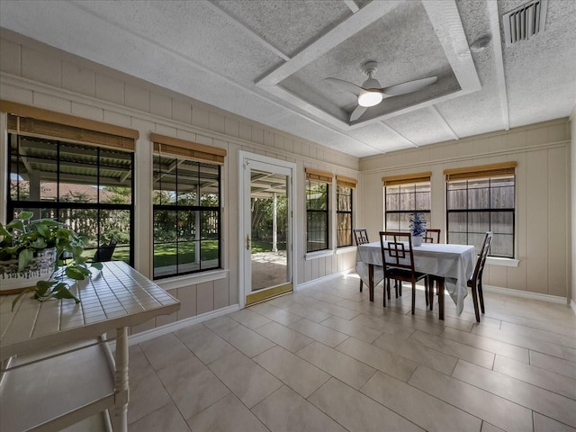 sunroom / solarium featuring a raised ceiling and ceiling fan