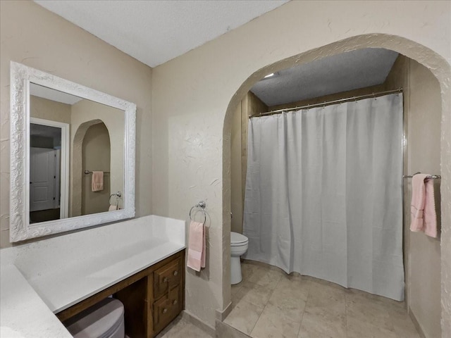 bathroom with vanity, a textured ceiling, toilet, and a shower with shower curtain