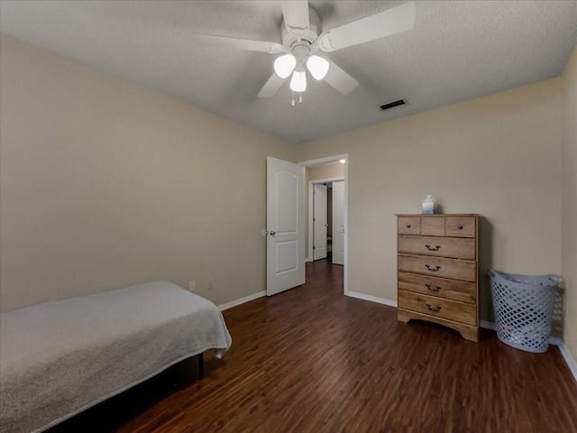 bedroom featuring ceiling fan, dark wood-type flooring, and a textured ceiling