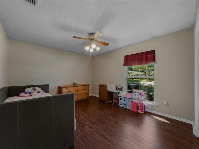 bedroom with ceiling fan, dark wood-type flooring, and a textured ceiling