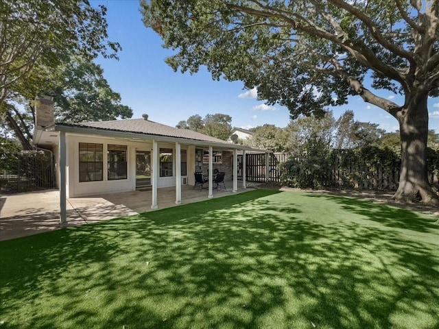 rear view of house with a yard and a patio area