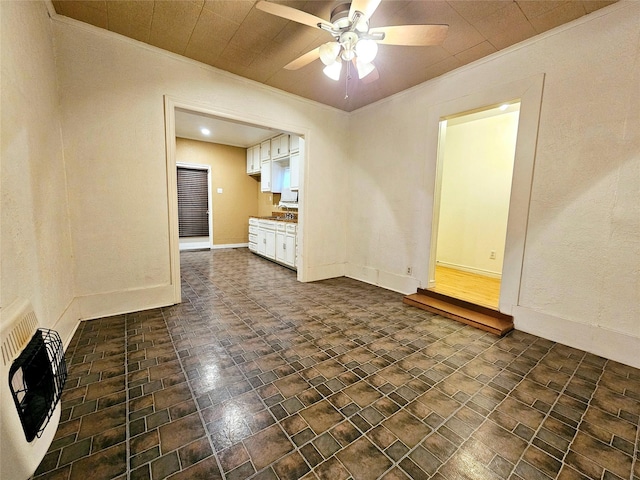 empty room featuring crown molding, heating unit, and ceiling fan