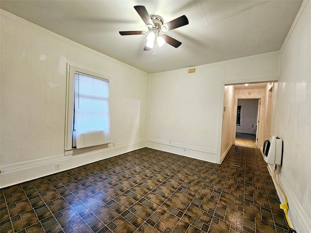 spare room featuring crown molding, ceiling fan, and heating unit