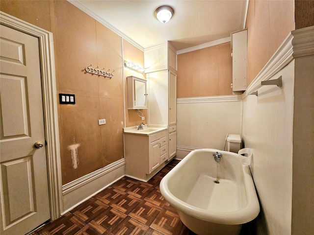 bathroom with crown molding, vanity, a bathtub, and parquet flooring