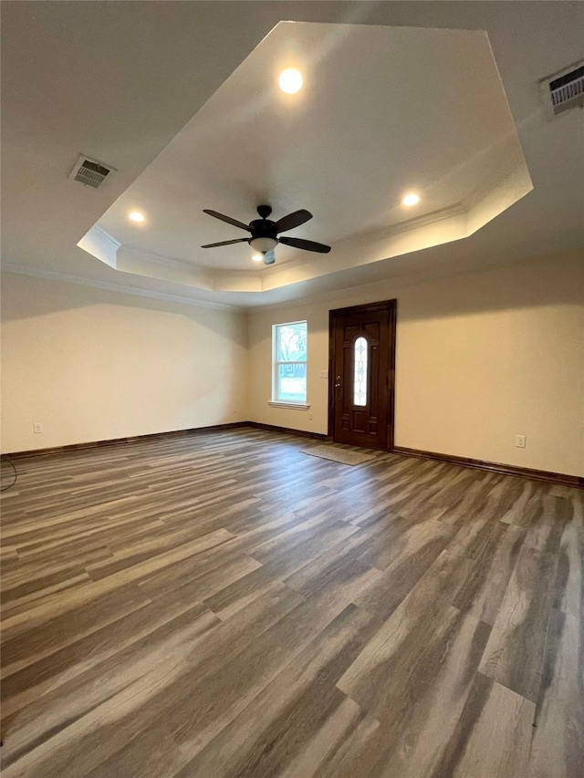 spare room with dark hardwood / wood-style flooring, a raised ceiling, and ceiling fan