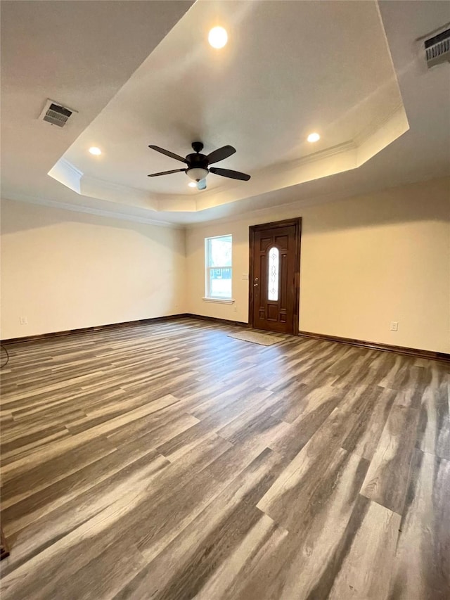 unfurnished room featuring hardwood / wood-style flooring, ceiling fan, and a tray ceiling