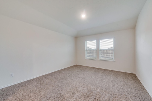 unfurnished room featuring vaulted ceiling and carpet flooring