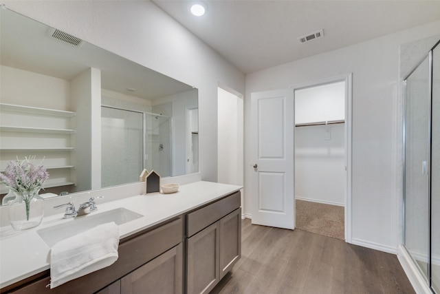 bathroom with vanity, hardwood / wood-style flooring, and walk in shower