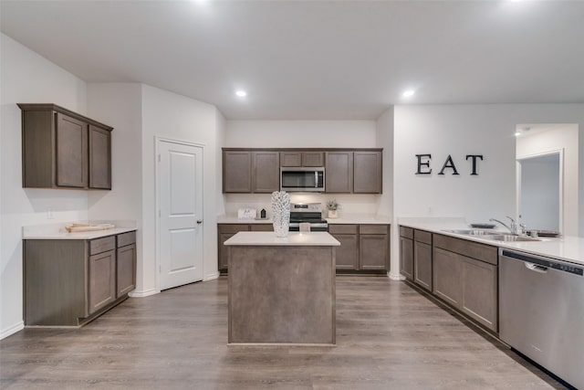 kitchen with stainless steel appliances, hardwood / wood-style flooring, sink, and kitchen peninsula