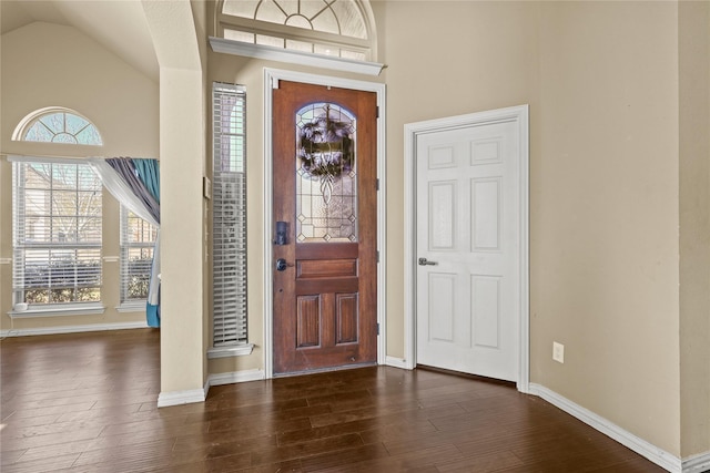 entryway with dark wood-type flooring and high vaulted ceiling