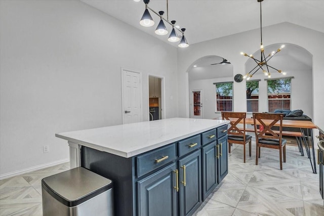 kitchen featuring vaulted ceiling, a kitchen island, decorative light fixtures, blue cabinets, and light parquet flooring